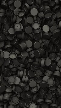 Pan across a pile of black plastic bottle caps for recycling and plastic industry production, 3D render dynamic Vertical video.
