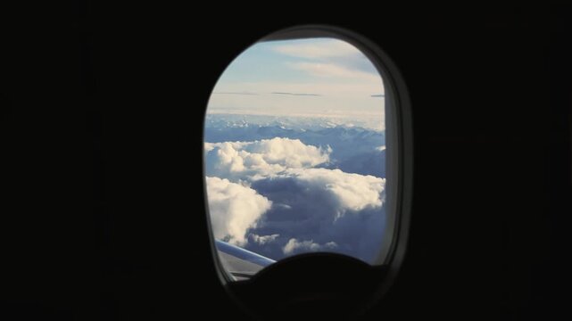Alps Majesty: Flying Over Clouds from a Plane Window