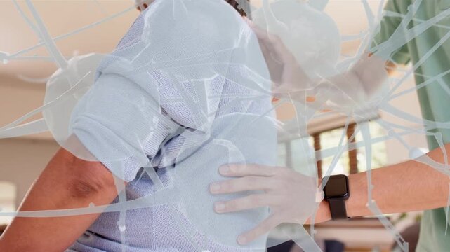 Adult man reaching from right, providing back support therapy at home, neural overlay showing hands