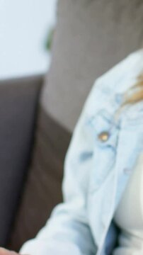Vertical video: Holding lady tapping tab case on lap at home as cam panning jean jacket, copy space