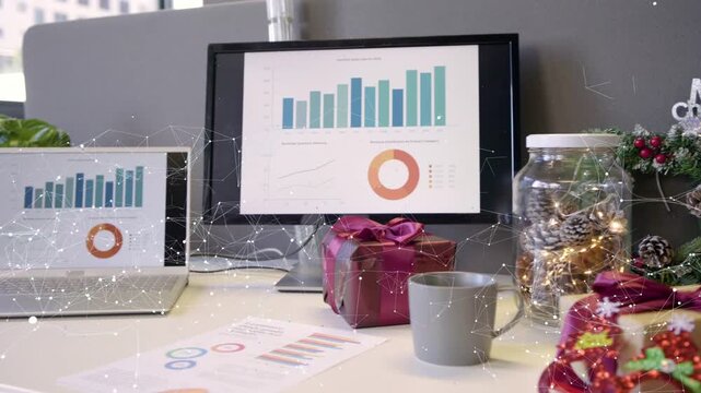Camera panning right revealing workstation decorating for holidays, laptop charts staying visible