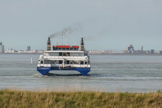 20 June 2026, Vlissingen, Netherlands. Passenger ferry approaching harbor with visible exhaust emissions and coastal city skyline