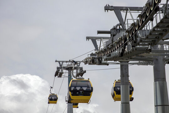 La Paz, Bolivia - January 12, 2018: Yellow gondolas of the Mi Teleferico transit system pass through a mechanical support tower