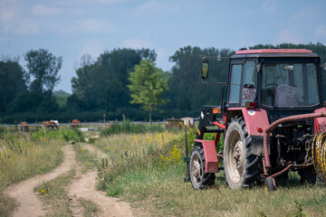 Fototapeta premium Agricultural tractor on rural dirt road near pasture in Hungary