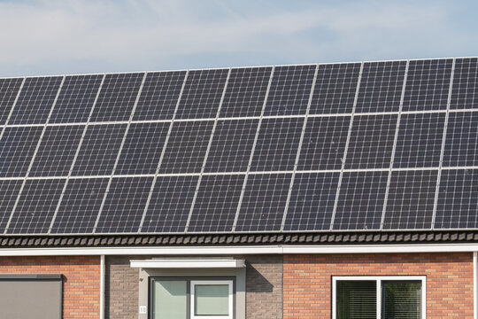Breskens, Netherlands. Residential house with rooftop solar panels generating renewable energy in suburban environment