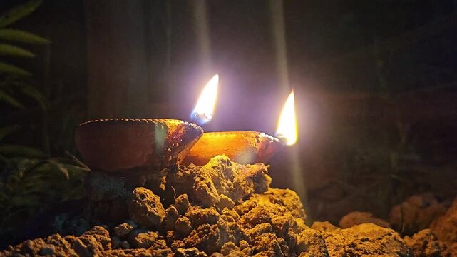 Traditional oil lamp Diya during a Hindu prayer ceremony at night.