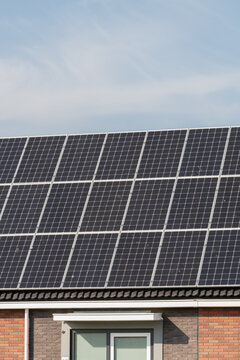 Breskens, Netherlands. Close-up of rooftop solar panels on residential building producing renewable electricity