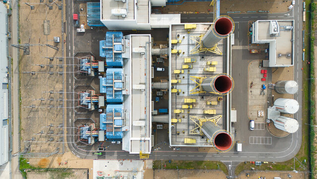 Aerial view of Rye House Power Station featuring industrial chimneys, electrical transformers, and storage tanks within the facility in Hoddesdon, England, United Kingdom.