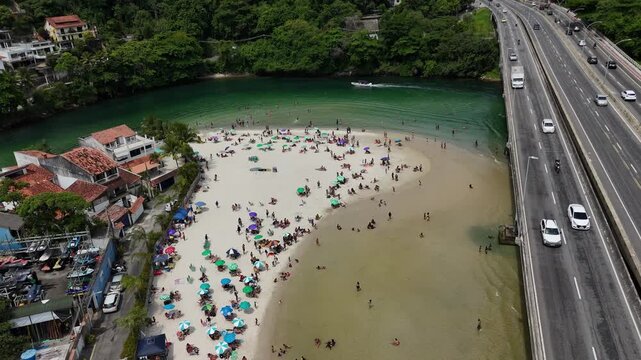 Pedra da Gavea aerial tilt down revealing Praia dos Amores, Barra da Tijuca, Rio de Janeiro