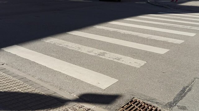 Empty textured walkway lines painted on asphalt street pavement symbolizing civic design, traffic rules, and pedestrian rights in the city