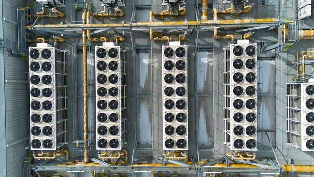 Aerial view of Rye House Power Station featuring rows of industrial cooling fans and yellow piping in Hoddesdon, England, United Kingdom.