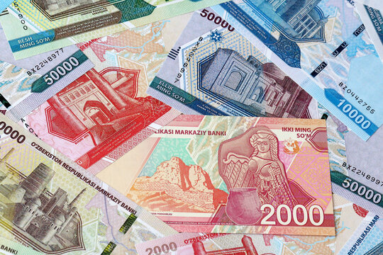Uzbekistani som money bills in pile on table. Uzbekistan UZS currency cash close up