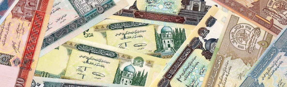 Afghan afghani money bills in pile on table. Afghanistan AFN currency cash close up