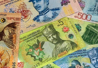 Brunei Darussalam dollar money bills in pile on table. Brunei BND currency cash close up © Viktor