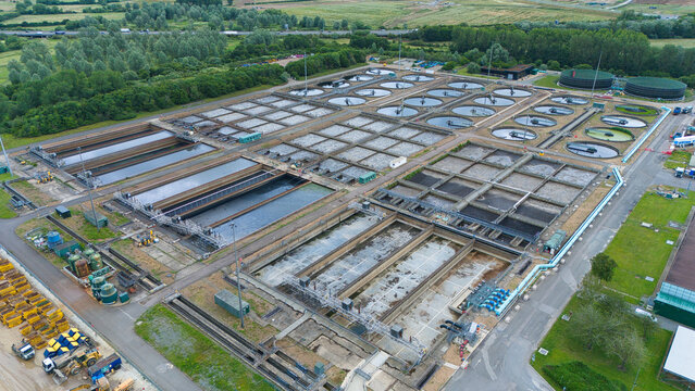 Aerial view of the Alpheus Wastewater Sewage Treatment works featuring circular sedimentation tanks and rectangular aeration basins in Milton Keynes, England, United Kingdom.
