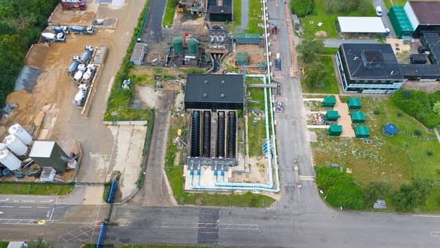 Aerial view of the Alpheus Wastewater Sewage Treatment works featuring industrial infrastructure, large screw pumps, and storage tanks, Milton Keynes, England, United Kingdom.