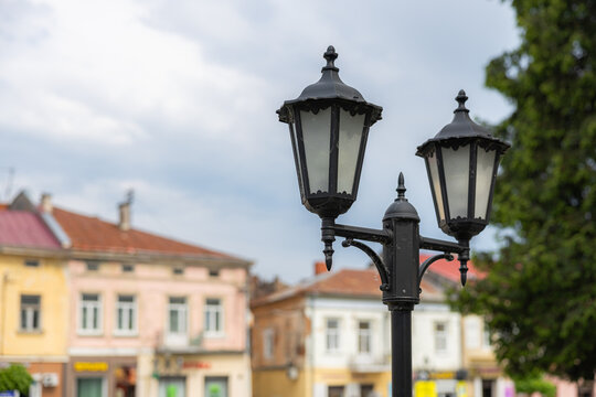 Vintage street lantern close up with blurred old town buildings in Drohobych Ukraine
