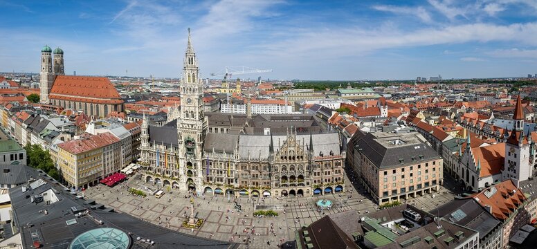 Aerial view of the historic Marienplatz square featuring the Neues Rathaus with its ornate Gothic architecture and the iconic Frauenkirche in Munich, Bavaria, Germany.
