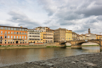 Fototapeta premium Famous historic Ponte Vecchio bridge and old buildings along the Arno river in Florence Italy