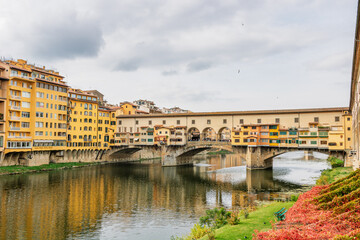 Fototapeta premium Famous historic Ponte Vecchio bridge and old buildings along the Arno river in Florence Italy