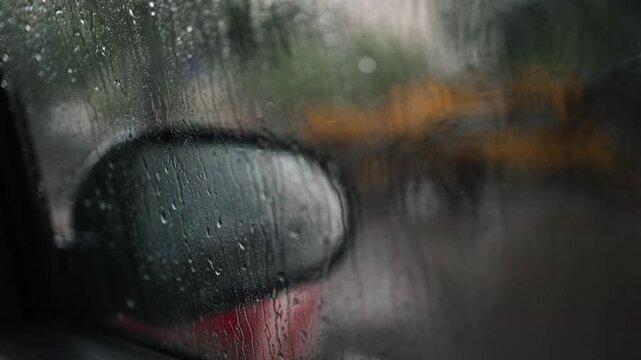 Glass rain auto. A car ride in a heavy downpour. Blurry traffic on the road, headlights of oncoming cars out of focus. The concept of bad weather, storm, hurricane. A gray, rainy, dreary autumn day.