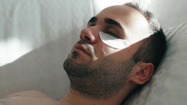 Close-up of young person applying under eye patches and nose strip