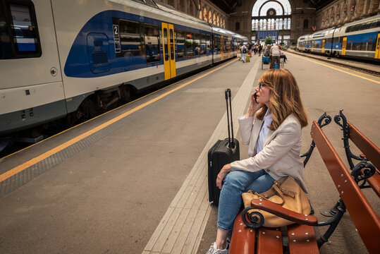 Mature woman talking on phone at railway station
