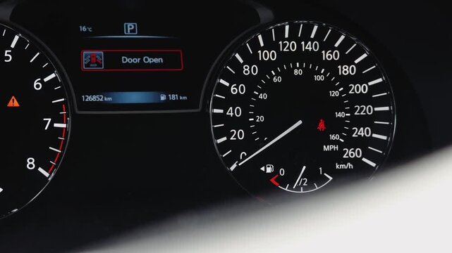 Car instrument cluster showing low tire pressure and safety warning lights