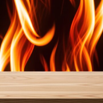 Wooden table surface sits in front of a backdrop of dancing orange flames.