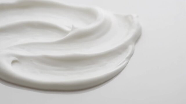 White cosmetic cream texture being swirled on smooth surface. Skincare product application and beauty industry marketing