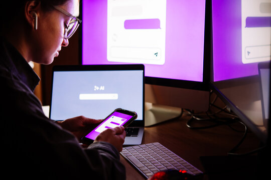 Young woman writing AI promt in a modern office.