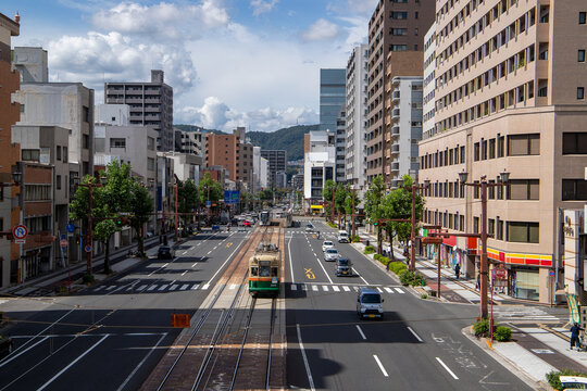 晴天の広島市街地を走る路面電車と高層ビル群、日常の風景