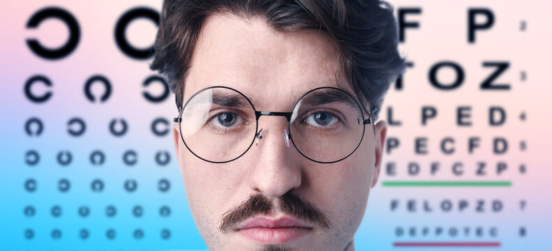Man in glasses and eye chart on color gradient background, selective focus. Vision check