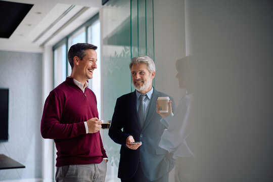 Happy business team talking during their coffee break in office.