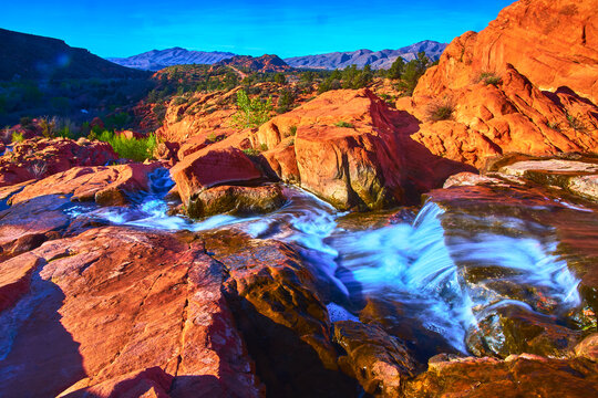 Vivid Waterfall Flow Over Red Rocks in Scenic Utah Desert Landscape