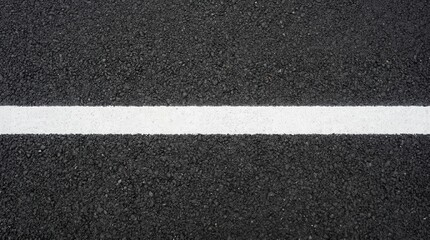 Fototapeta premium Close-up view of a white line painted on a dark asphalt road surface.