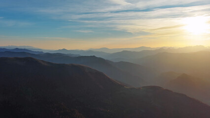 Fototapeta premium Flying over colorful foliage at sunset in mountains