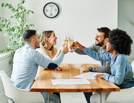 A portrait of young businesspeople celebrating business success with a tost  in the office, teamwork and togetherness concept