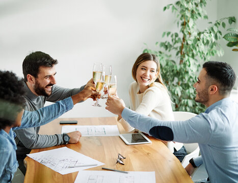 A portrait of young businesspeople celebrating business success with a tost  in the office, teamwork and togetherness concept