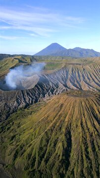 Aerial view of Mount Bromo crater, Mount Batok and Mount Semeru at sunrise in East Java, Indonesia. Spectacular volcanic landscape featuring three iconic volcanoes.