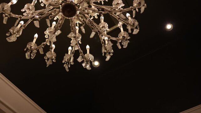 Elegant crystal chandelier on dark ceiling