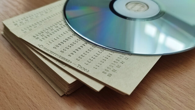 Evolution of data storage: vintage punch cards and modern CD DVD disc