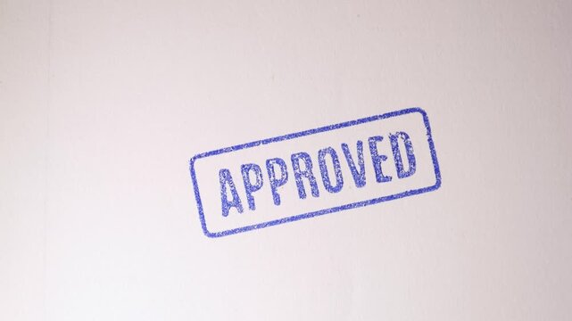 Blue "APPROVED" stamp being freshly printed onto an official business profile document.