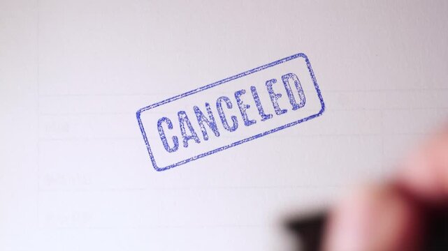Blue "CANCELED" stamp being freshly applied onto an official profile document.