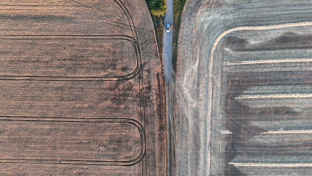 Drone view of harvested wheat fields at sunset near Baracs