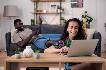 Fototapeta premium Multicultural couple working remotely from home living room