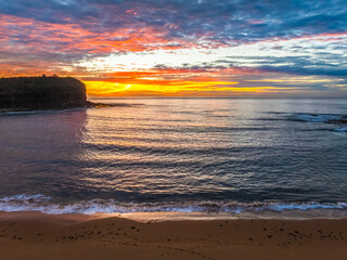 Obraz premium Sunrise Seascape with Calm Seas and a Cloud Covered Sky