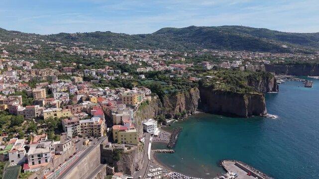 Aerial view of Meta di Sorrento and Piano di Sorrento colorful coastal towns with Marina di Alimuri beach, dramatic tuff cliffs, and Gulf of Naples, Italy