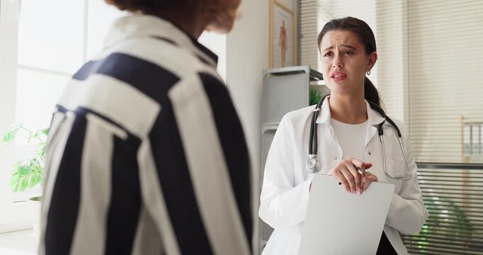 Doctor and patient woman discuss healthcare diagnosis results. Female physician listens, explains options and outlines next steps in clinic consultation. Concept of concern and support.