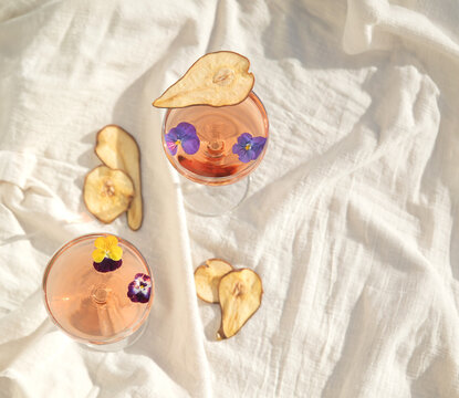 Two rose wine glasses on white fabric top view. Summer cocktails
